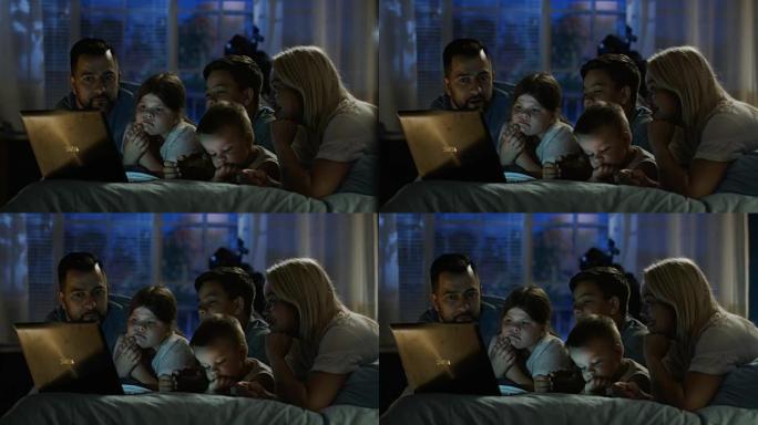 内容家庭在笔记本电脑上观看有趣的电影