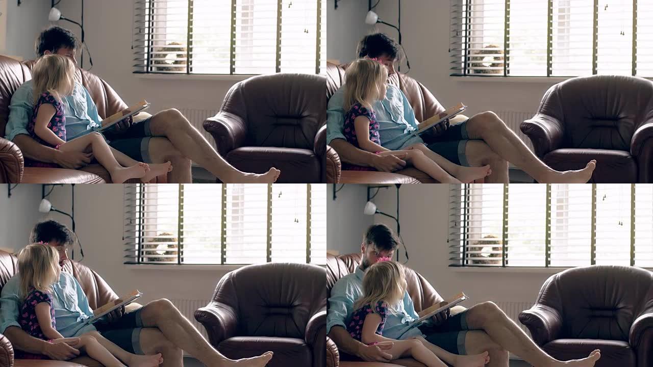 一个年轻的父亲和他快乐的金发小女儿正在餐厅的皮沙发上读一个故事。全高清