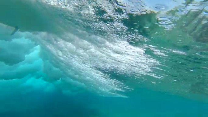 低角度: 年轻的极限运动员沿着史诗般的Cloudbreak wave骑着冲浪板。