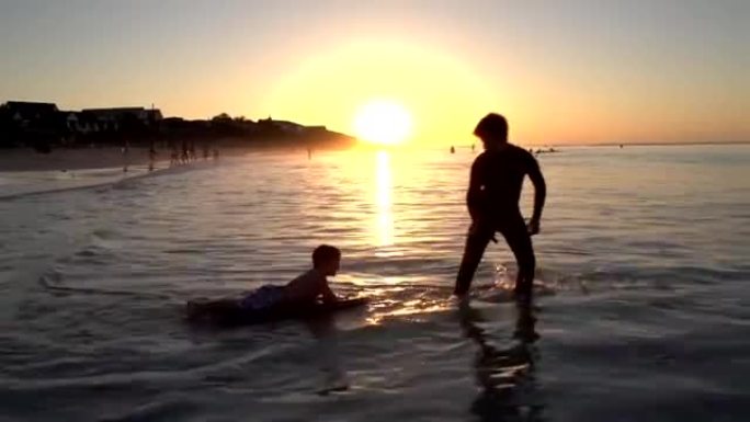 开普敦日落时分，两个小男孩在沙滩上玩耍