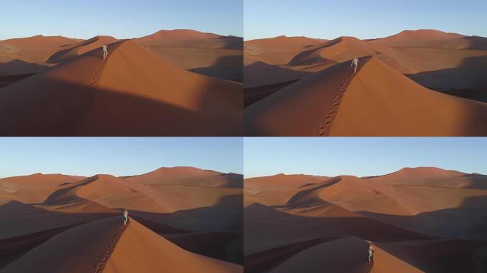 飞越男性游客的视线，走上纳米布沙漠中巨大的沙丘之一
