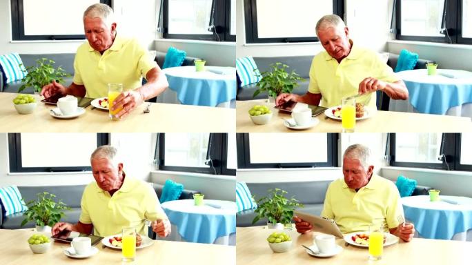 退休男子吃早餐时使用平板电脑