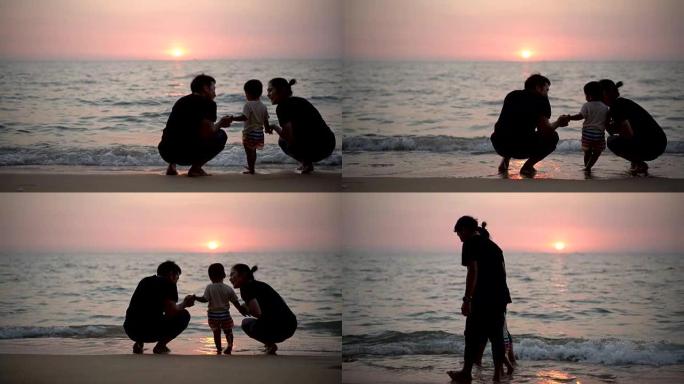 剪影家庭和男婴在日落时手牵手一起在海滩上散步。