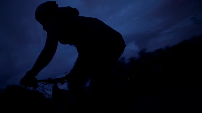 山路上骑自行车者剪影的中等镜头