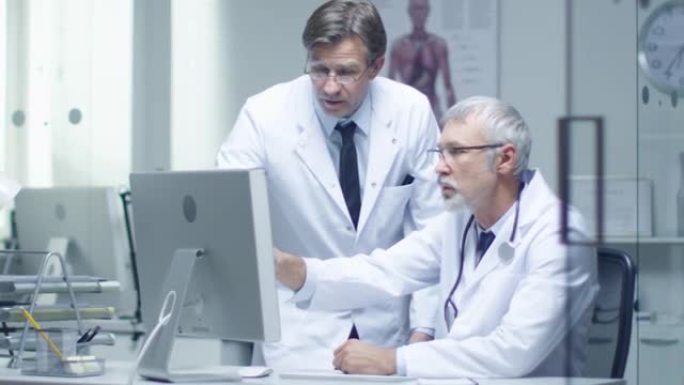 高级医生和他的助手在个人电脑上讨论病人的日志。慢动作。