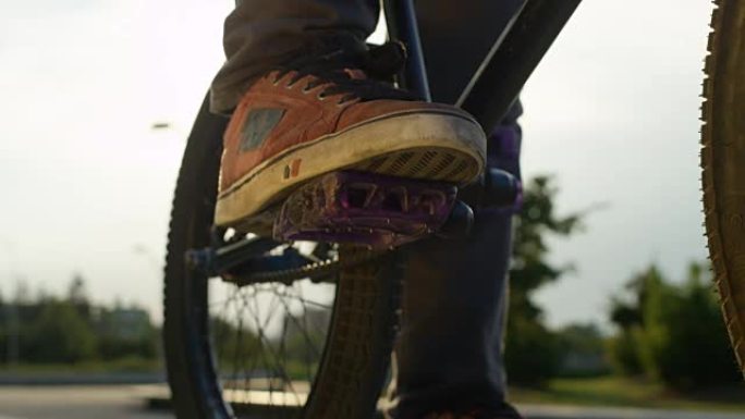 慢动作特写: Bmx自行车手旋转并将脚放在自行车踏板上