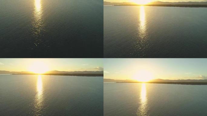 空中: 灿烂的金色阳光照耀着深蓝色的海浪，逼近岛屿。