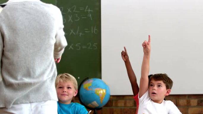 可爱的小学生在教室里举手