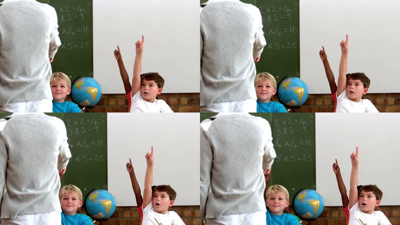 可爱的小学生在教室里举手