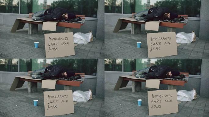 由于欧洲的移民危机，无家可归和失业的欧洲男子在城市街道的长凳上睡觉