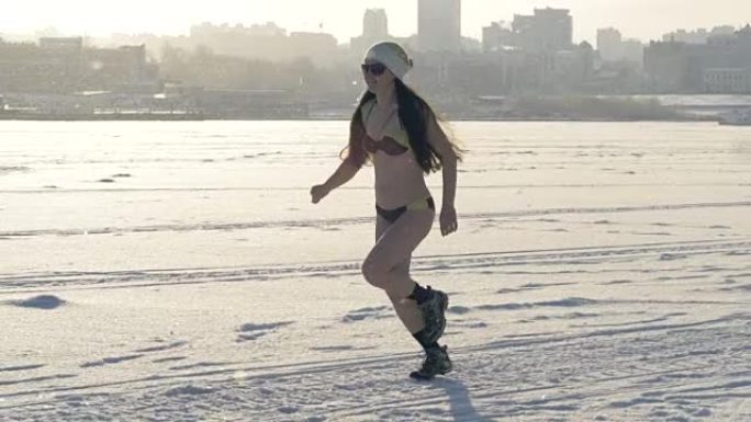 一个穿着靴子和比基尼的女人在冬天跑步。