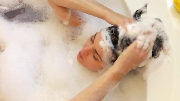 女人在泡泡浴中洗头的俯视图