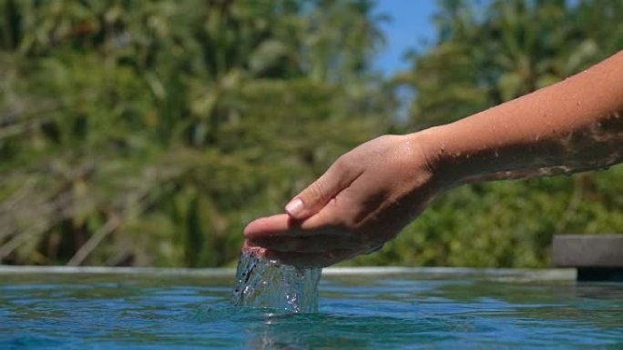 特写: 人的手在丛林水池中sc起水并倒水