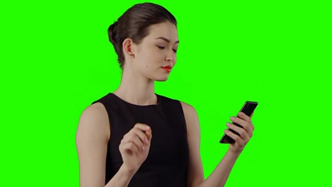 在绿屏上使用智能手机的女商人