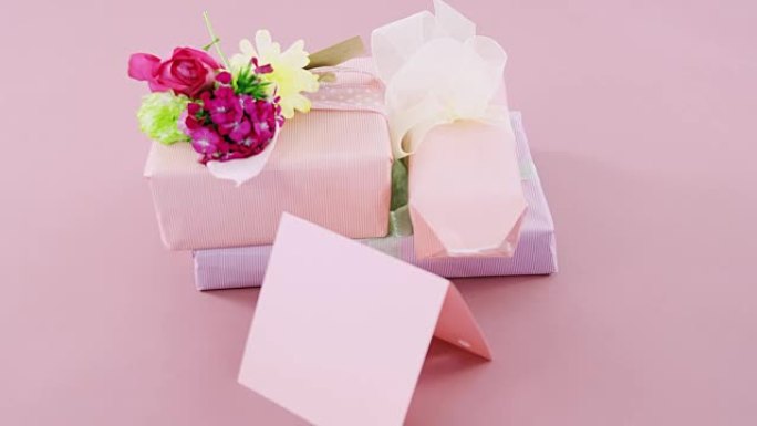 粉色背景下的鲜花和空白卡片礼品盒