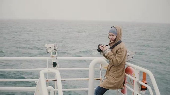 年轻的女记者站在船上，在阴天用相机拍照