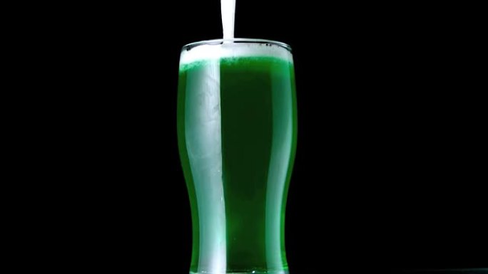 泡沫掉入一品脱的绿色啤酒中