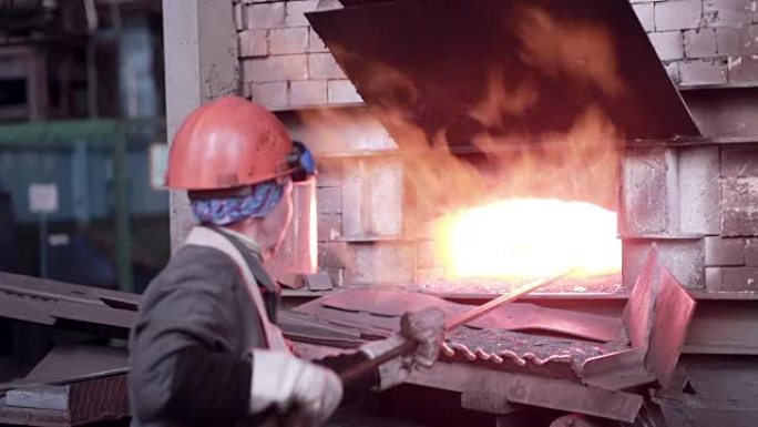 在冶金厂用熔炉熔化的液态熔融金属工作的女人