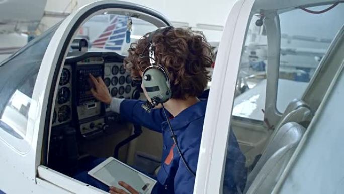 女性飞行员用平板电脑检查驾驶舱