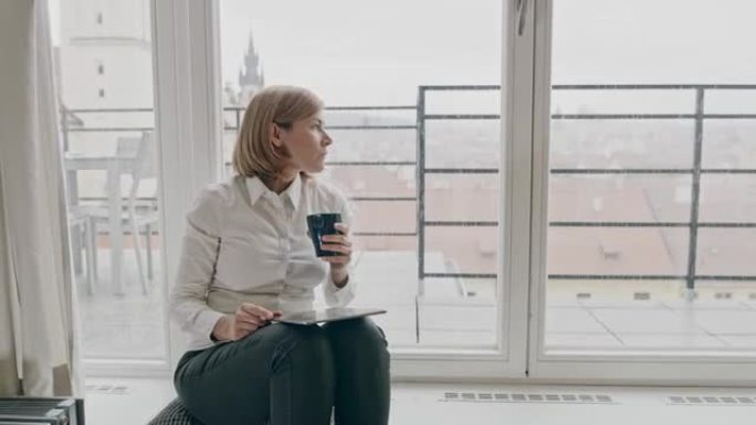 WS女商人使用数字平板电脑并在家中喝咖啡