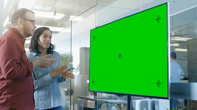 会议室的男女讨论了模拟色键绿屏电视。