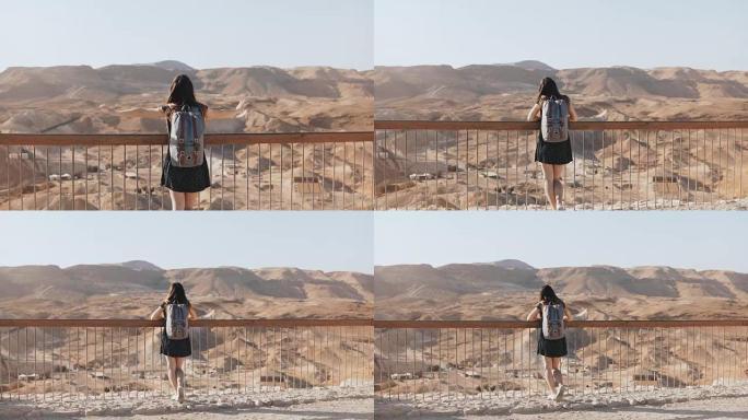 女孩站在巨大的山景上，双臂张开。漂亮的欧洲女人快乐而兴奋。自由。以色列马萨达。4K