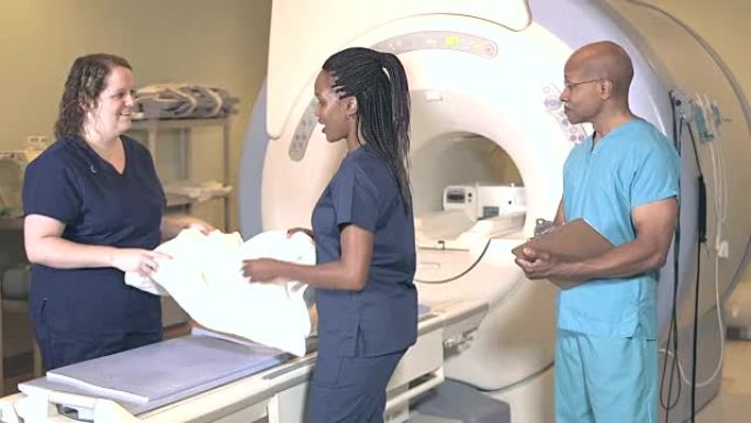 在MRI扫描仪室工作的三名医疗专业人员
