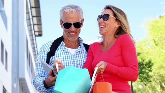 成熟的夫妇在购物后看着书包和大笑