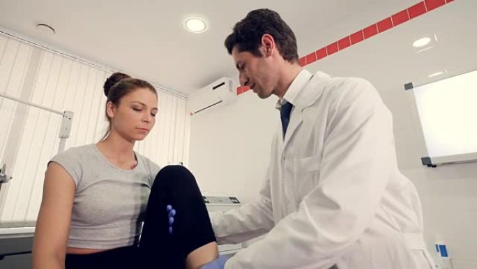 特写。男医生检查病人腿，预约医疗理念。