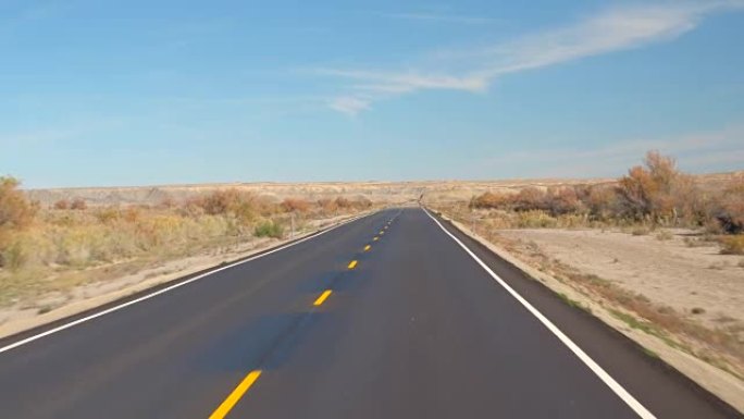 FPV: 在美国犹他州秋天，沿着空旷的道路穿越广阔的沙质沙漠