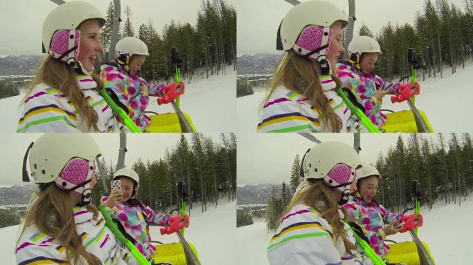 两个年轻女孩在滑雪山上坐升降椅
