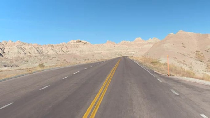 FPV: 沿着空旷的道路行驶，穿过风景秀丽的荒地山沙漠