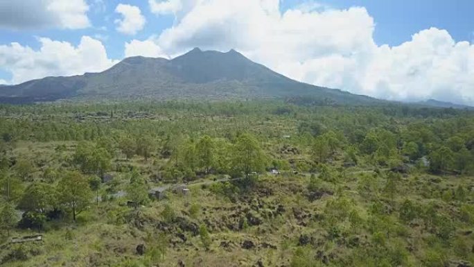 空中: 通往阳光明媚的巴厘岛雄伟的巴图尔火山的道路上的交通