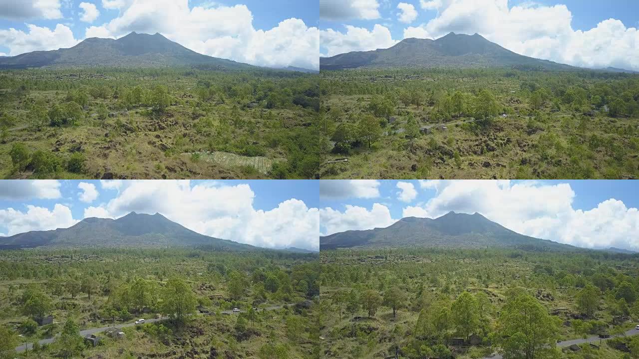 空中: 通往阳光明媚的巴厘岛雄伟的巴图尔火山的道路上的交通