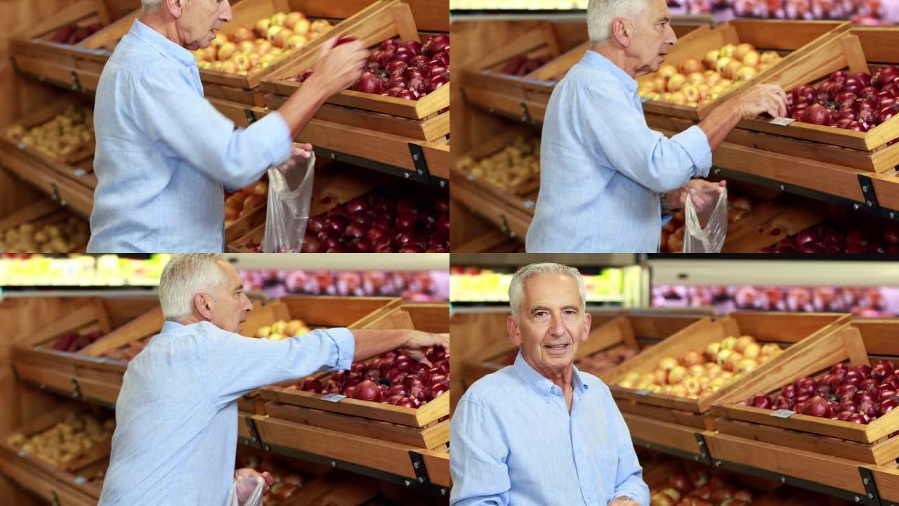 高级男子在超市挑选苹果