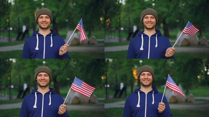 慢动作肖像的蓄着胡子的美国人骄傲的公民挥舞着美国官方旗帜，看着镜头与高兴的微笑。人、国家和景观的概念