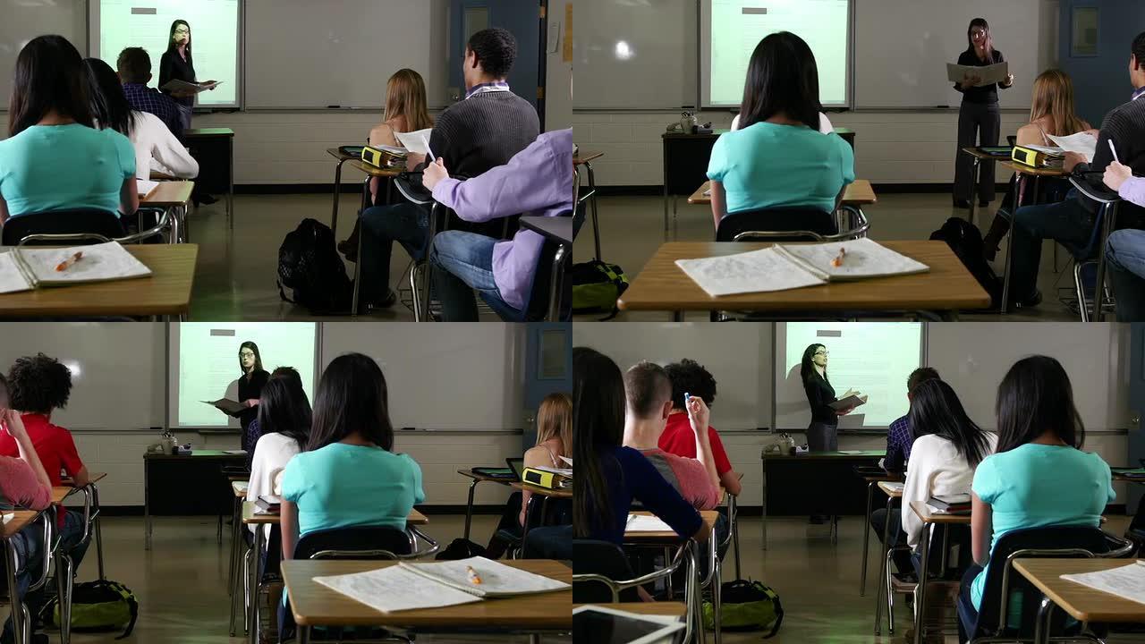高中生向老师和互动白板学习。