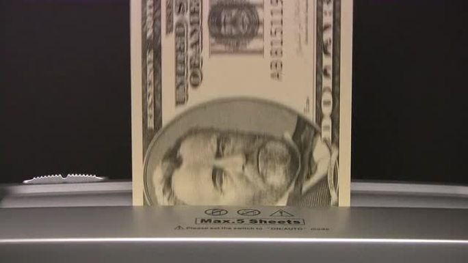 美元钞票被碎纸机撕碎。通货资金钱