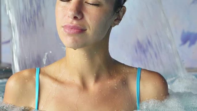 美丽的年轻女子在水疗按摩浴缸中放松