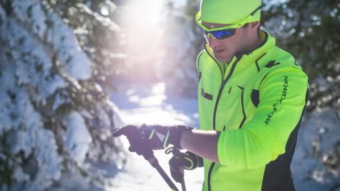 冬季景观中的男运动员，检查智能手表