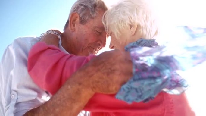 老年活跃的老年人在海滩上拥抱