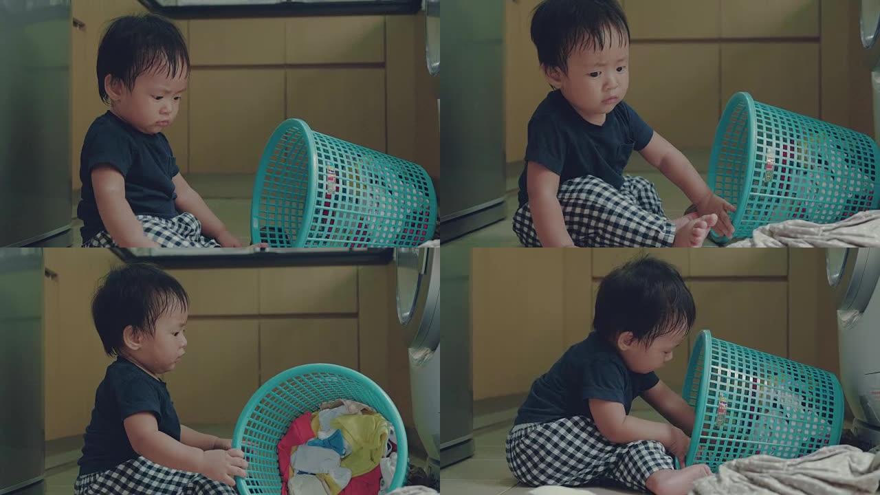 亚洲男婴学习在家折叠衣物