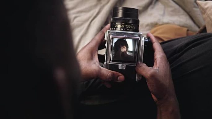 人的特写镜头打开了旧的移动fil摄像机的录像机盖。摄影师拍摄年轻女子的照片