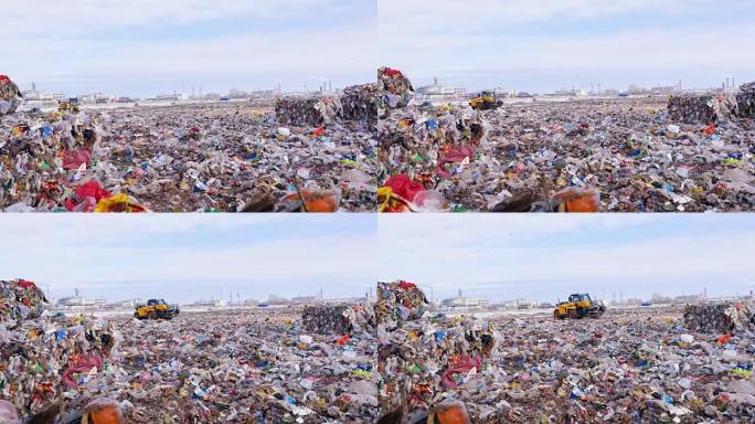 垃圾填埋场装载机在压缩垃圾堆之间移动。环境污染概念。