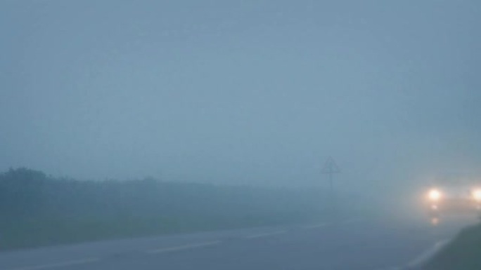 汽车在乡村道路上穿过浓雾