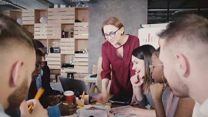 女组长向员工解释新任务。快乐的多种族同事在办公室会议上集思广益4K