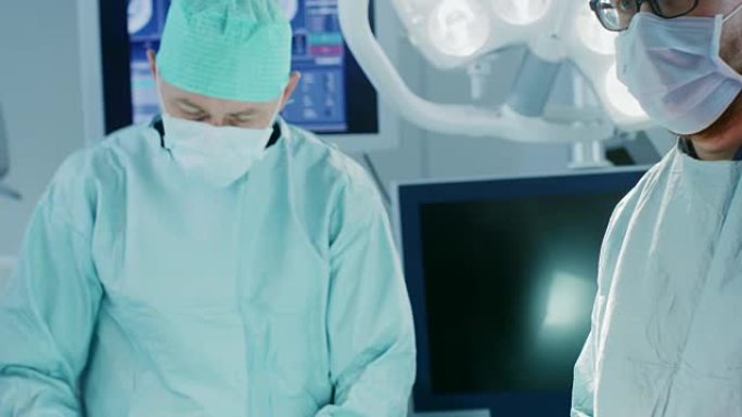 手术室的特写镜头助手在手术期间将仪器交给外科医生。手术正在进行中。进行手术的专业医生。