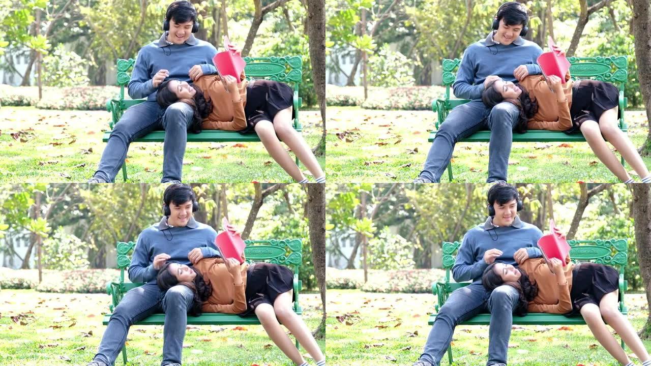 幸福的年轻夫妇在公园的长凳上放松。