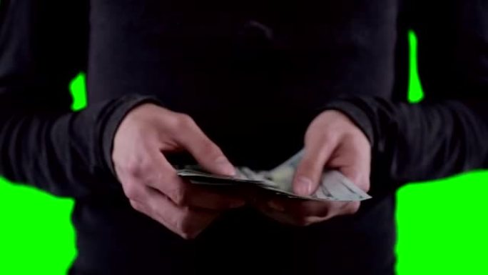 一个面目全非的人手里拿着钱，数着钱，在色马基上显示着美元。近距离