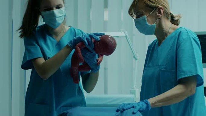 在医院的妇女在分娩和分娩，婴儿出来，产科医生协助分娩，丈夫支持他的妻子。侧视镜头。